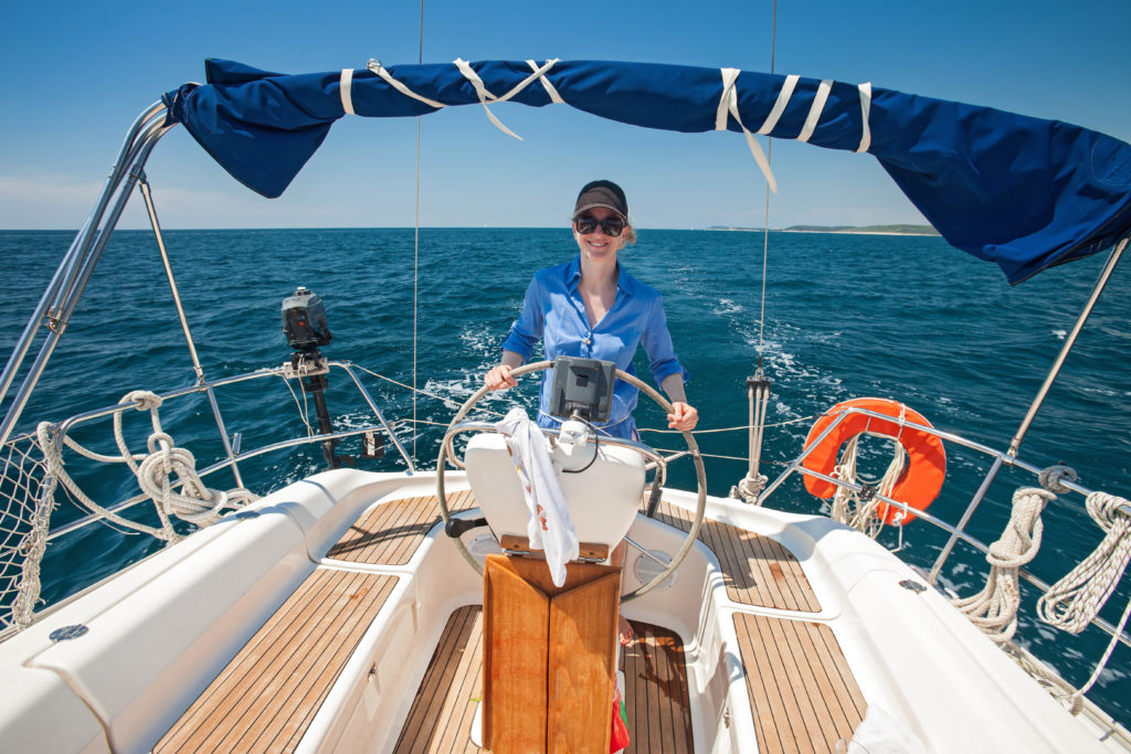 Young woman standing at the helm of a boat